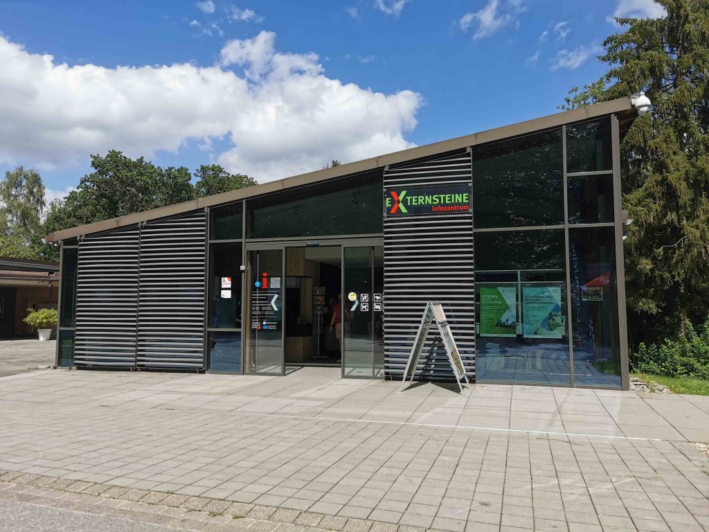 Die **Externsteine**, ein uraltes, mystisches Naturdenkmal mitten im Teutoburger Wald, zogen mich in ihren Bann. Schon die Anfahrt war gut organisiert: Mit einem **Parkticket** für 4,00 Euro ging es den teerbefestigten Berg hinauf. Links und rechts reihten sich Parkplätze im Schatten der Bäume, einige davon mit **Schotteruntergrund**, die jedoch wenig barrierefreundlich waren.